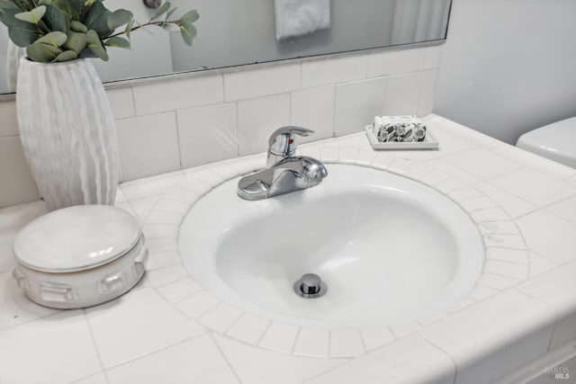 room details with toilet, backsplash, and a sink