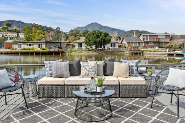 view of patio / terrace featuring an outdoor living space, a residential view, and a water and mountain view