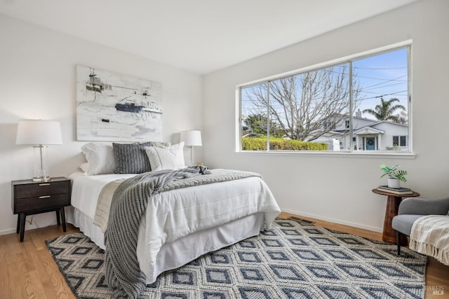 bedroom with baseboards and wood finished floors