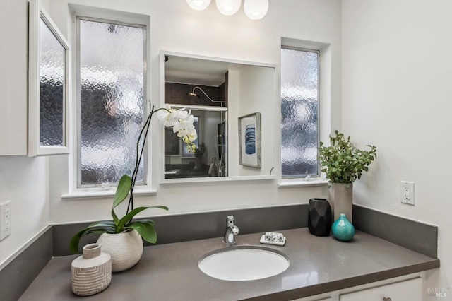 bathroom with a shower stall and vanity