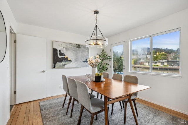 dining room with baseboards, hardwood / wood-style flooring, and an inviting chandelier