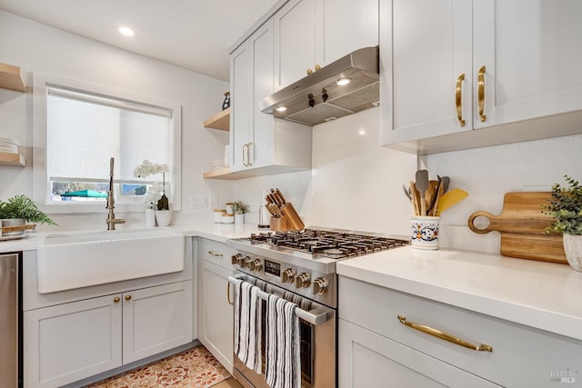 kitchen with high end stove, under cabinet range hood, a sink, light countertops, and open shelves