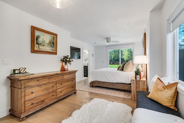 bedroom with light wood-style floors, access to outside, a textured ceiling, and a ceiling fan