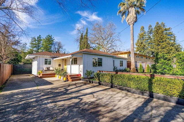 mediterranean / spanish house featuring covered porch, driveway, fence, and a gate