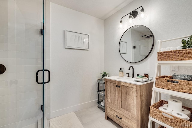 bathroom with a stall shower, vanity, and baseboards