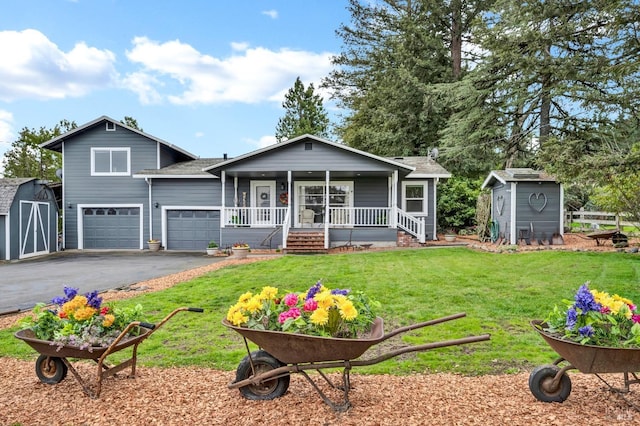 view of front facade featuring aphalt driveway, an outdoor structure, a porch, and a storage shed