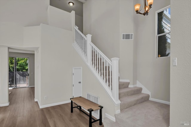 stairway with baseboards, visible vents, and wood finished floors