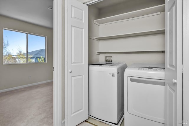 laundry area featuring laundry area, light carpet, baseboards, and separate washer and dryer