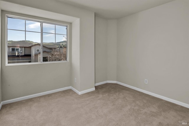 unfurnished room featuring carpet flooring and baseboards