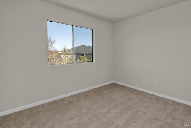 empty room with light colored carpet and baseboards