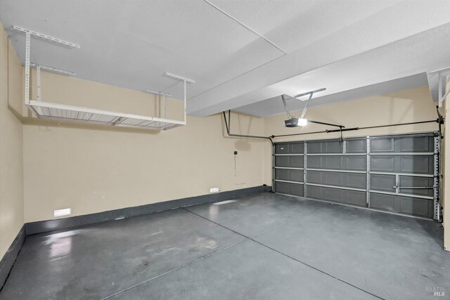 garage with baseboards and a garage door opener