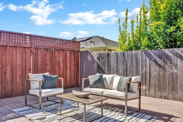 wooden terrace featuring a fenced backyard and an outdoor hangout area