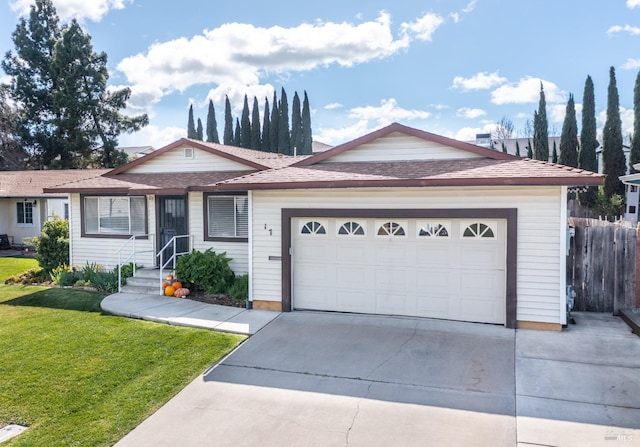 ranch-style home with concrete driveway, an attached garage, a front lawn, and fence