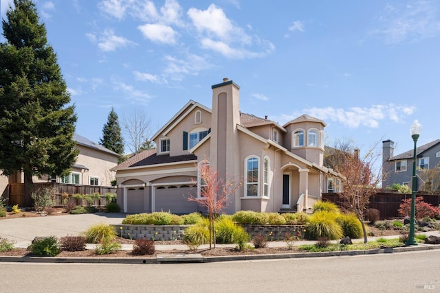view of front facade with concrete driveway, stucco siding, fence, and a chimney