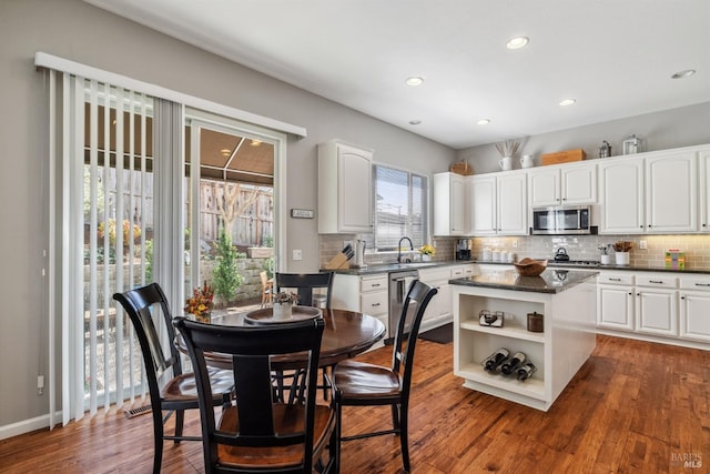 kitchen featuring open shelves, appliances with stainless steel finishes, dark wood finished floors, white cabinets, and decorative backsplash