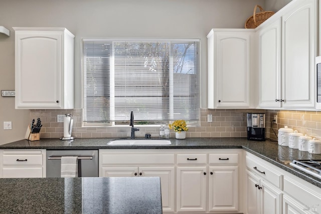 kitchen with white cabinetry, decorative backsplash, and a sink