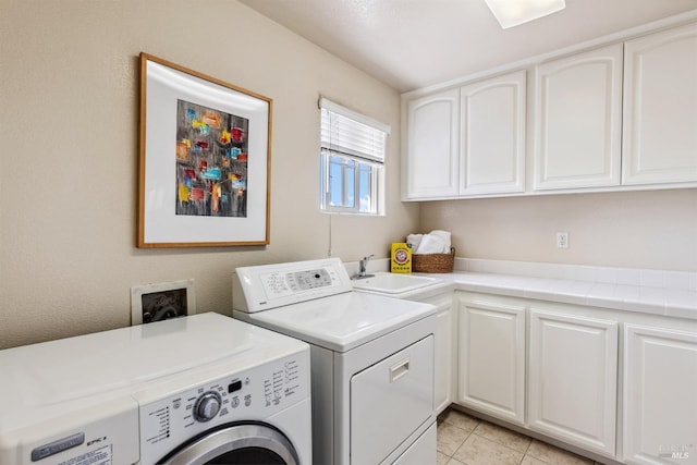 clothes washing area with independent washer and dryer, cabinet space, a sink, and light tile patterned floors