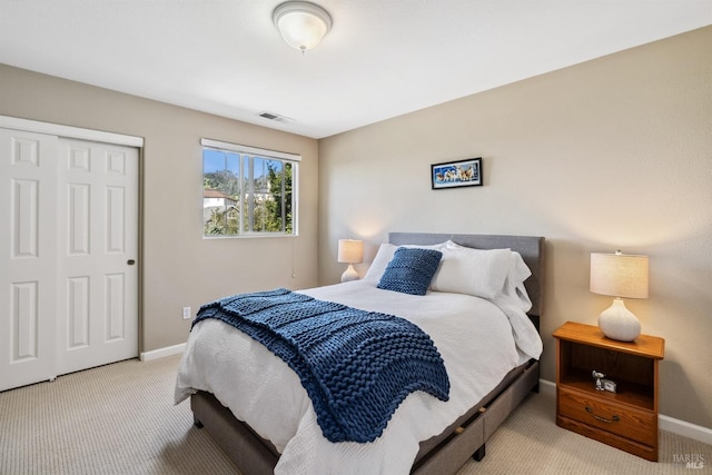 carpeted bedroom featuring a closet, baseboards, and visible vents