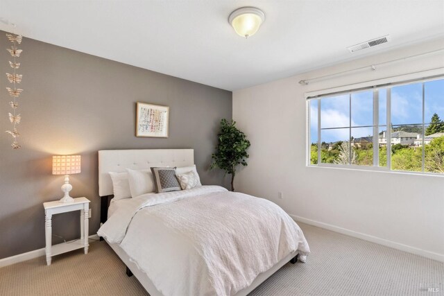 carpeted bedroom with baseboards and visible vents