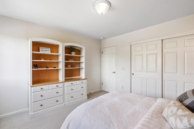 carpeted bedroom with a closet and baseboards