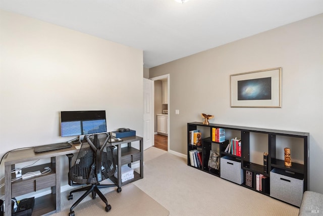carpeted home office featuring baseboards