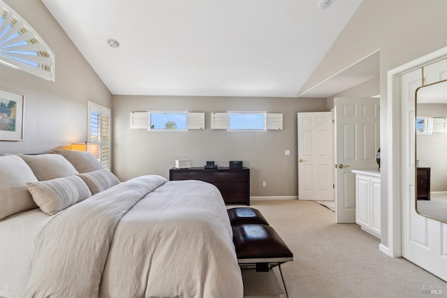 bedroom with light colored carpet, vaulted ceiling, multiple windows, and baseboards