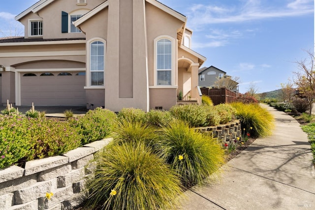 view of home's exterior with stucco siding and a garage