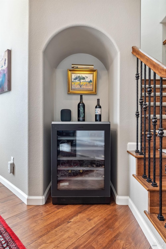 room details with baseboards, wood finished floors, and wine cooler
