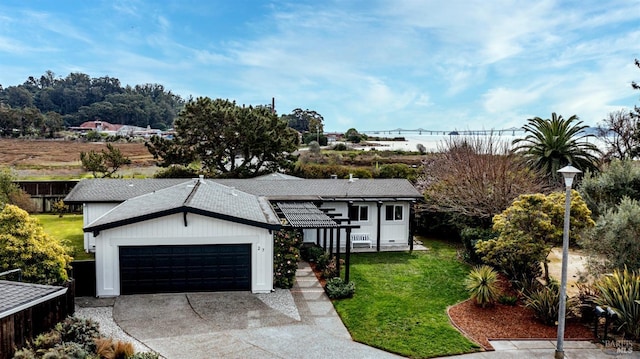 view of front of home with an attached garage, driveway, and a front lawn