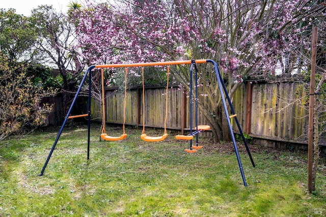 view of jungle gym featuring fence and a yard