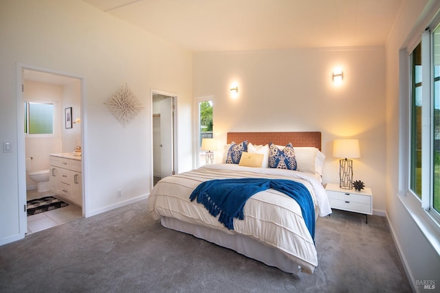 carpeted bedroom with baseboards, connected bathroom, and tile patterned floors