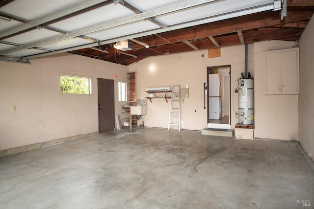 garage featuring secured water heater, a garage door opener, a sink, and freestanding refrigerator