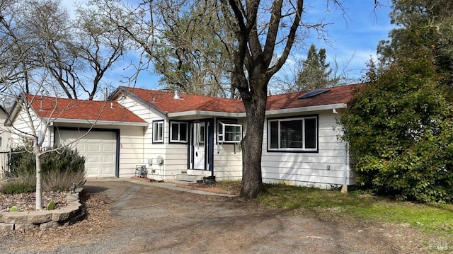 ranch-style home with aphalt driveway, an attached garage, and entry steps