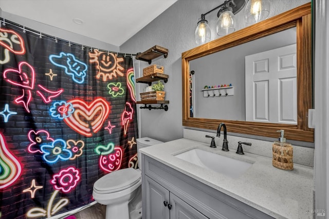 bathroom featuring vanity, a textured wall, toilet, a shower with shower curtain, and vaulted ceiling