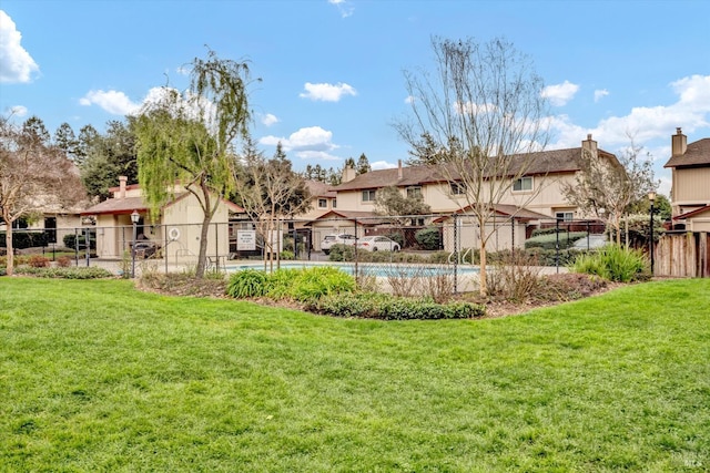 view of yard featuring a community pool and fence