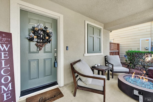 entrance to property featuring covered porch and stucco siding