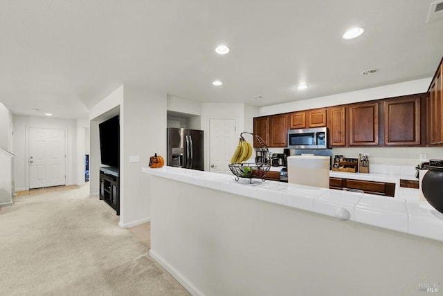 kitchen with tile countertops, recessed lighting, light carpet, baseboards, and appliances with stainless steel finishes