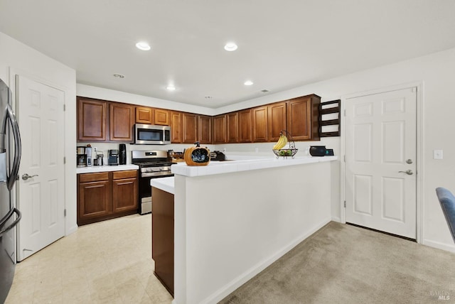 kitchen with recessed lighting, stainless steel appliances, a peninsula, baseboards, and light countertops