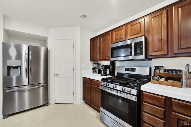 kitchen with stainless steel appliances and tile countertops