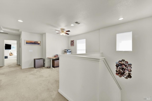 hallway featuring light carpet, recessed lighting, visible vents, and an upstairs landing