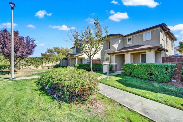 view of front of home featuring a front yard and stucco siding