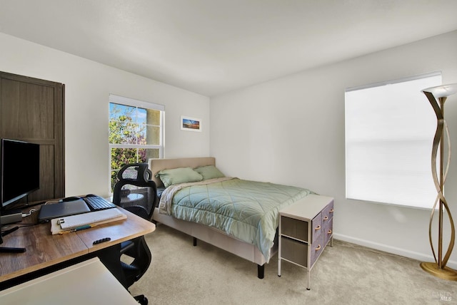 bedroom featuring light carpet and baseboards