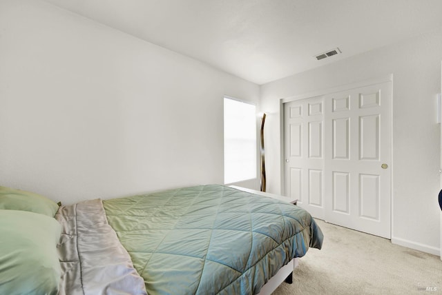 bedroom featuring carpet floors, a closet, visible vents, and baseboards