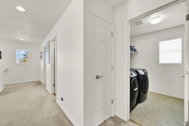 laundry room featuring laundry area, washing machine and dryer, baseboards, and light colored carpet