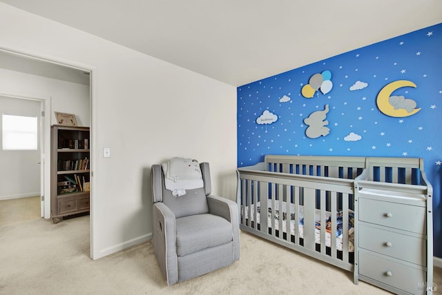 carpeted bedroom with baseboards, an accent wall, a nursery area, and wallpapered walls