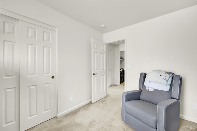 sitting room featuring light carpet and baseboards