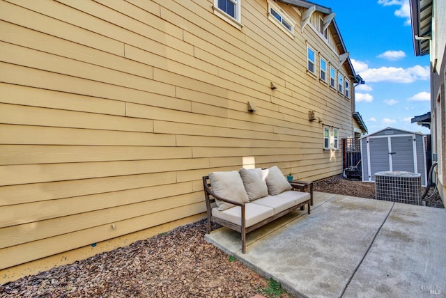 view of side of home featuring a patio, an outbuilding, a storage unit, central air condition unit, and an outdoor living space