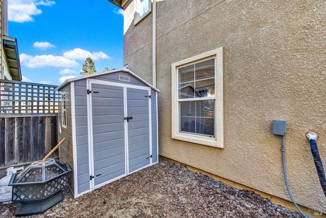 view of shed featuring fence