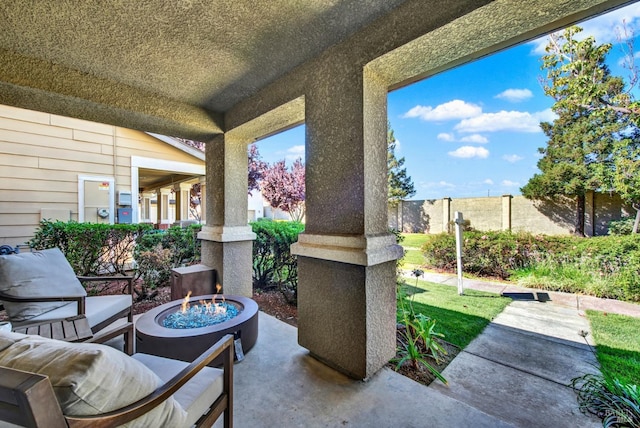 view of patio with an outdoor fire pit and fence
