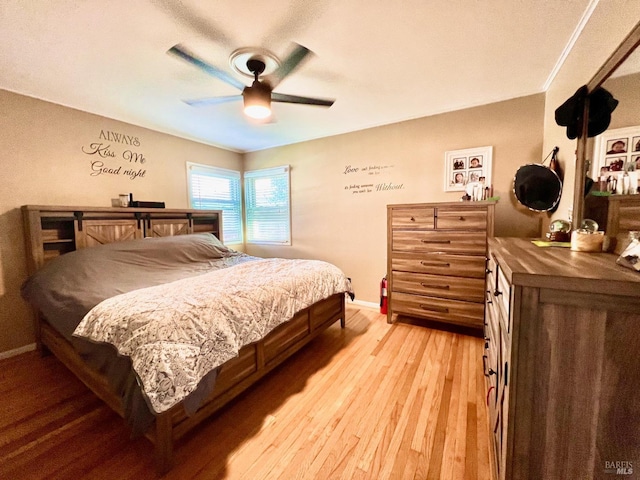 bedroom featuring a ceiling fan, light wood-style flooring, and baseboards